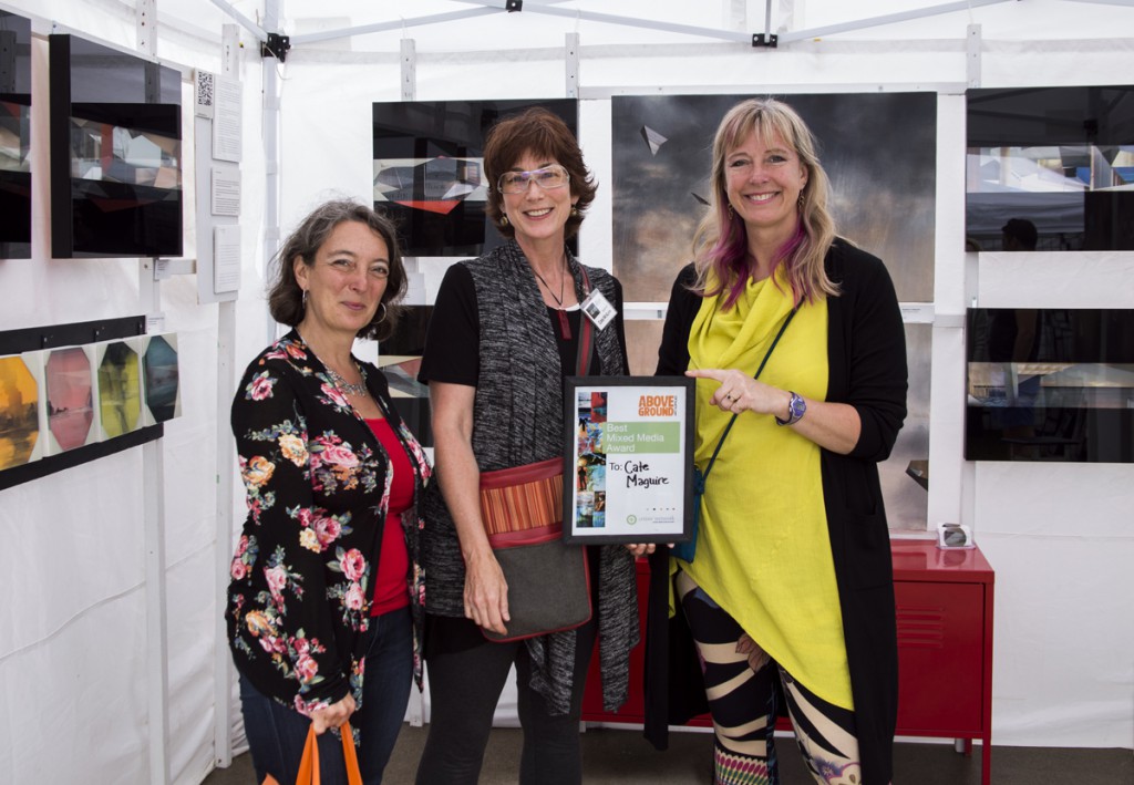 Art Bomb artist Cate McGuire with her Best Mixed Media Award for the Riverdale Art Walk. On her left is Julie Dabrusin, LIberal MP for Toronto Danforth, and on her right is Kate Taylor, Chair of the Board for the Artists Network.